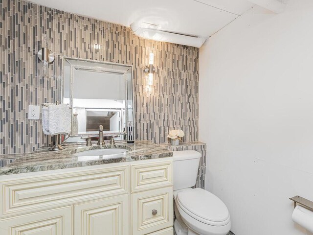 16 Joan Dr, Yonkers, NY 10704 - bathroom with toilet, vanity, and decorative backsplash