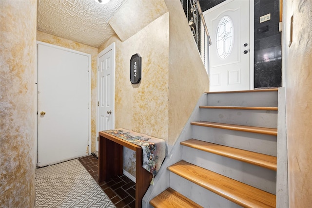 stairs with a textured ceiling and brick floor