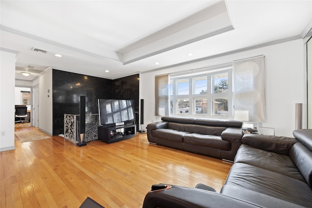 living area featuring recessed lighting, a raised ceiling, visible vents, and wood-type flooring