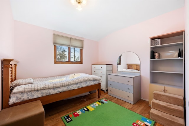 bedroom with lofted ceiling and wood finished floors