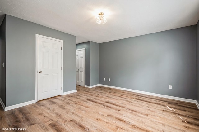 unfurnished bedroom featuring a closet, baseboards, and wood finished floors