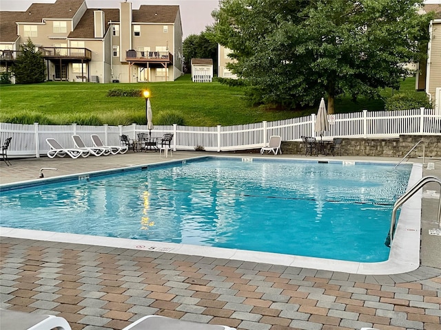 community pool featuring fence and a patio