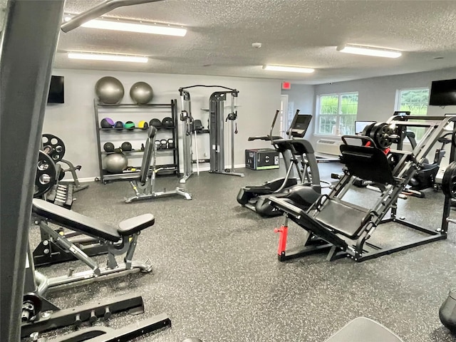 gym with baseboards and a textured ceiling