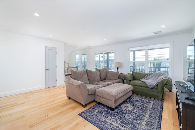 living room with baseboards, visible vents, light wood-style flooring, crown molding, and recessed lighting