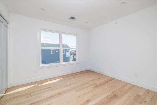 unfurnished room with baseboards, visible vents, wood finished floors, and recessed lighting