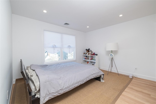 bedroom with baseboards, visible vents, wood finished floors, and recessed lighting