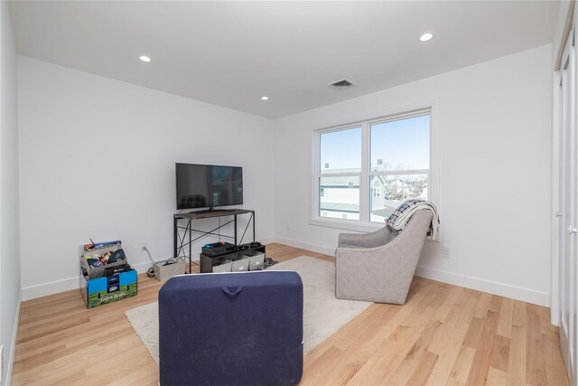 living area featuring baseboards, visible vents, wood finished floors, and recessed lighting