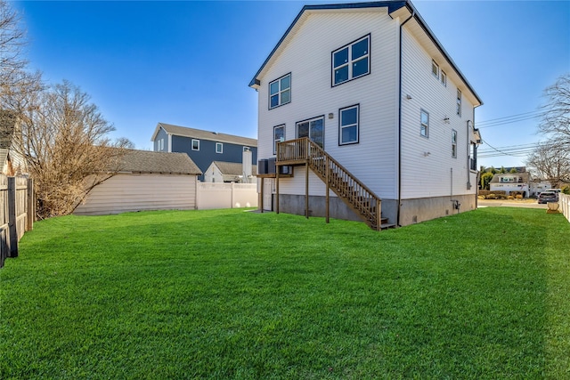 back of property with a fenced backyard, a yard, and stairs