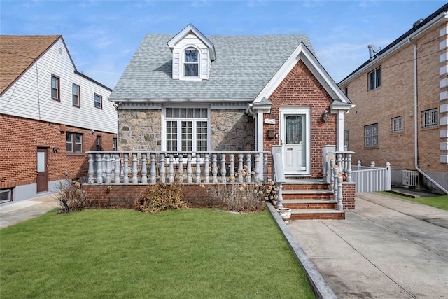 view of front of house featuring central AC unit, covered porch, stone siding, roof with shingles, and a front yard