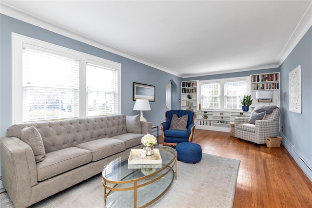 living area featuring crown molding, wood finished floors, baseboards, and baseboard heating