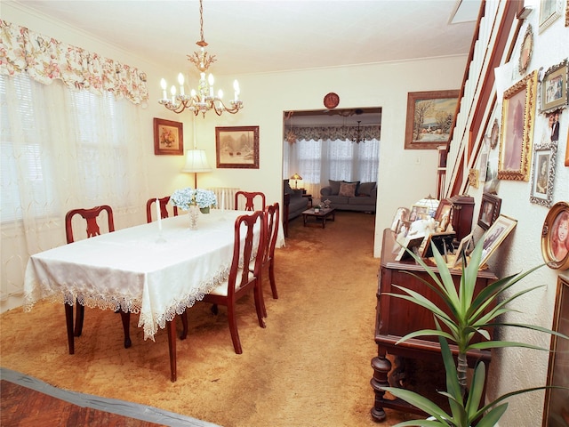 carpeted dining area with a chandelier and ornamental molding