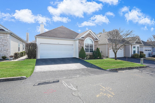 ranch-style house with a shingled roof, a front lawn, a chimney, stone siding, and driveway