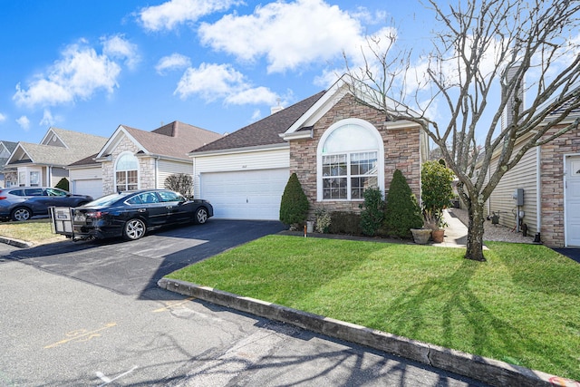 view of front of property with aphalt driveway, roof with shingles, a garage, stone siding, and a front lawn