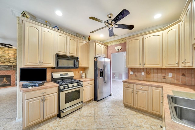 kitchen featuring stainless steel appliances, a ceiling fan, light countertops, backsplash, and light brown cabinetry