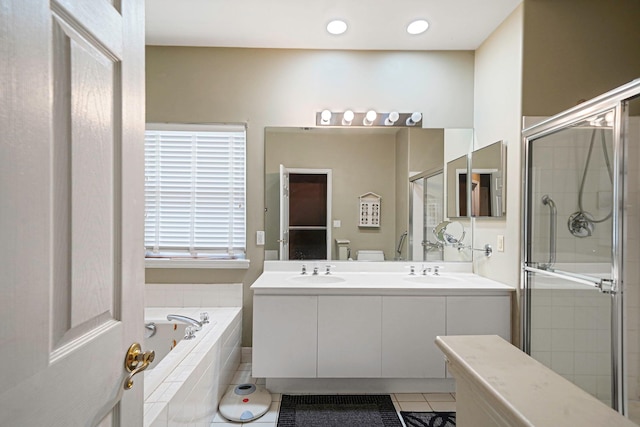 full bath featuring double vanity, a stall shower, tile patterned flooring, and a sink