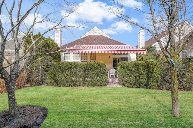 view of front of home with a chimney, a gate, and a front yard