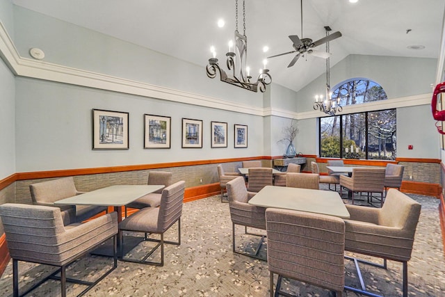 interior space featuring high vaulted ceiling and ceiling fan with notable chandelier