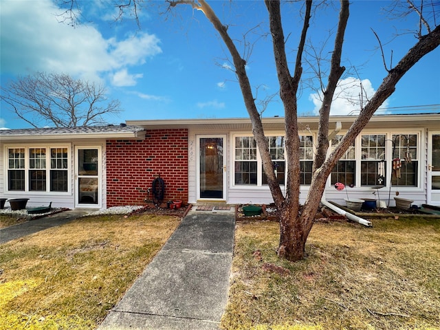 view of front facade with a front yard and brick siding