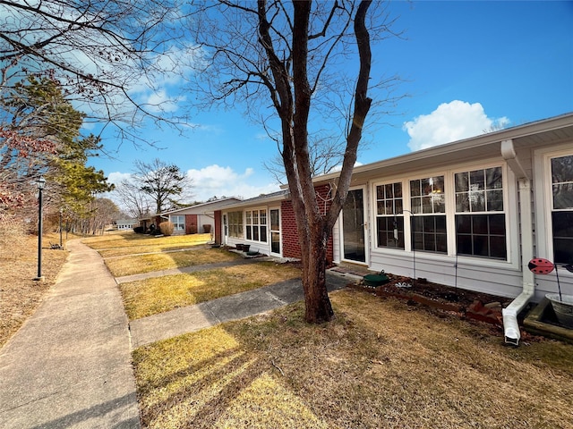 view of front of property featuring brick siding and a front yard