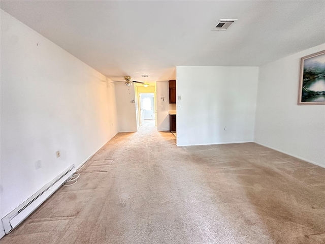 empty room featuring visible vents, light carpet, and baseboard heating