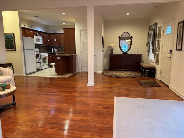 foyer with recessed lighting, baseboards, and wood finished floors