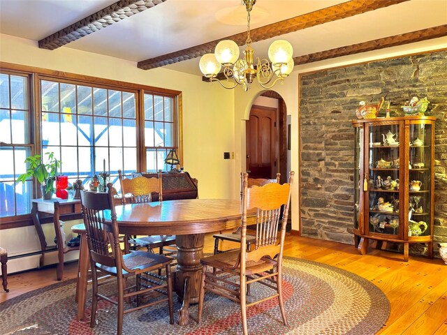 2838 Old Kings Rd, Catskill, NY 12414 - dining space featuring arched walkways, wood-type flooring, beam ceiling, a chandelier, and plenty of natural light