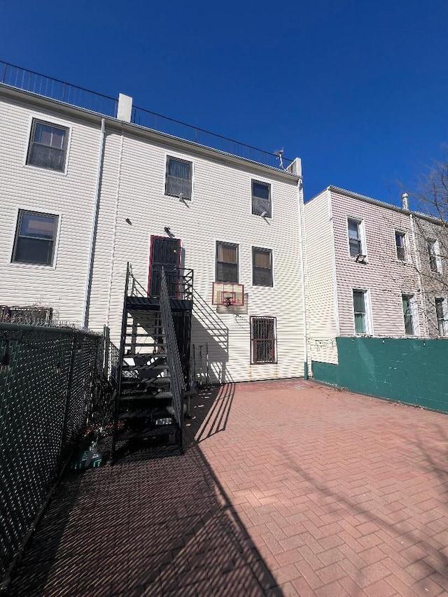 back of house with stairway, a patio area, and fence