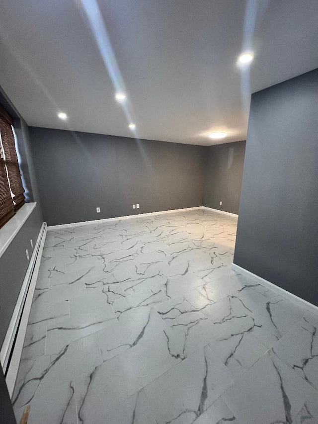 finished basement with a baseboard radiator, marble finish floor, baseboards, and recessed lighting