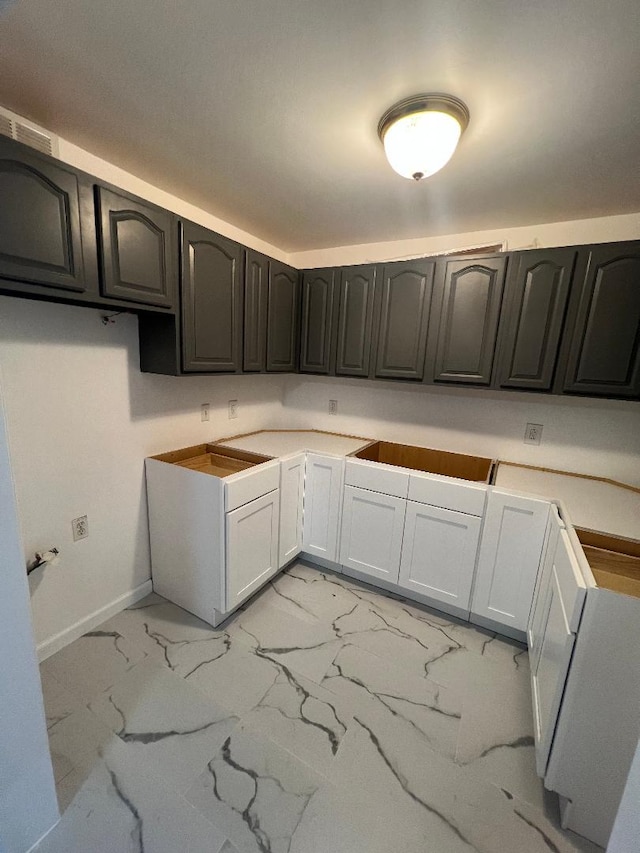 kitchen featuring marble finish floor, visible vents, and baseboards