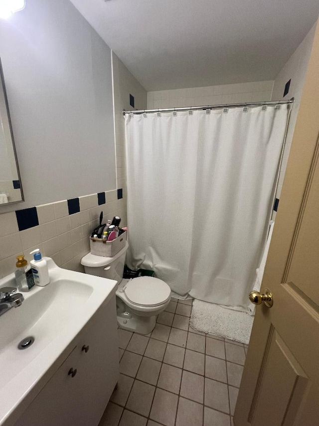 bathroom featuring tile patterned flooring, toilet, vanity, tile walls, and a shower with curtain