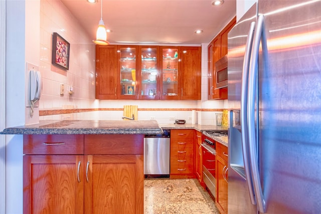 kitchen with stainless steel appliances, brown cabinetry, glass insert cabinets, and decorative backsplash