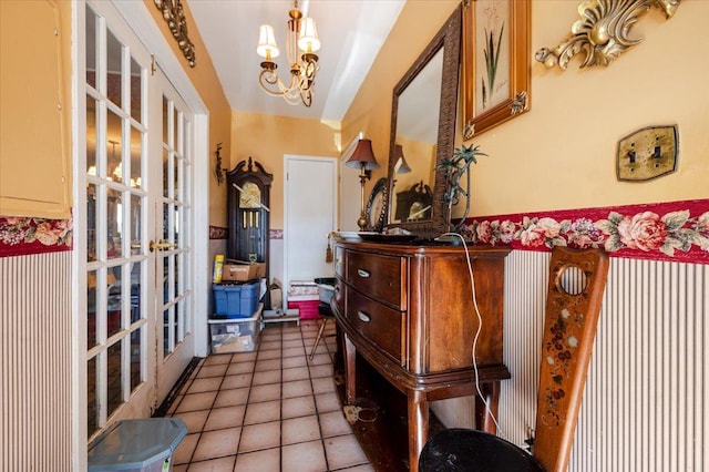 interior space with tile patterned floors, french doors, and a notable chandelier