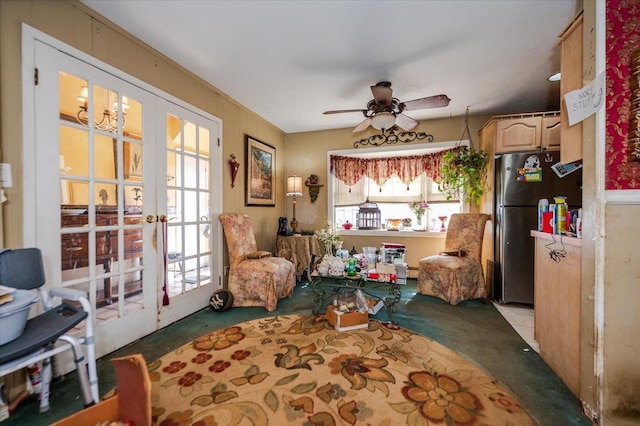 living area with a ceiling fan and french doors