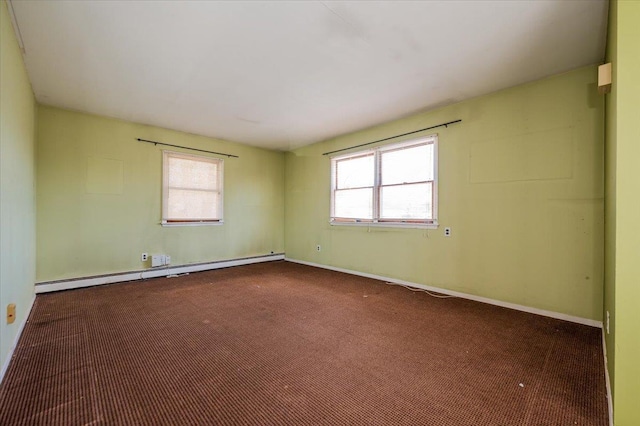 spare room with baseboard heating, baseboards, and dark colored carpet