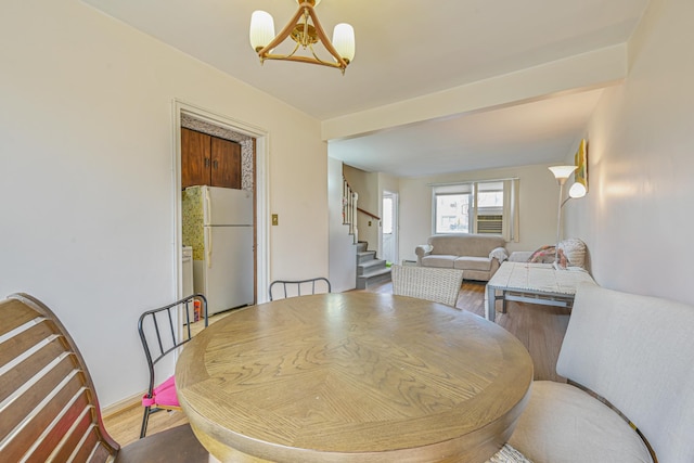 dining space with stairway, a chandelier, and wood finished floors