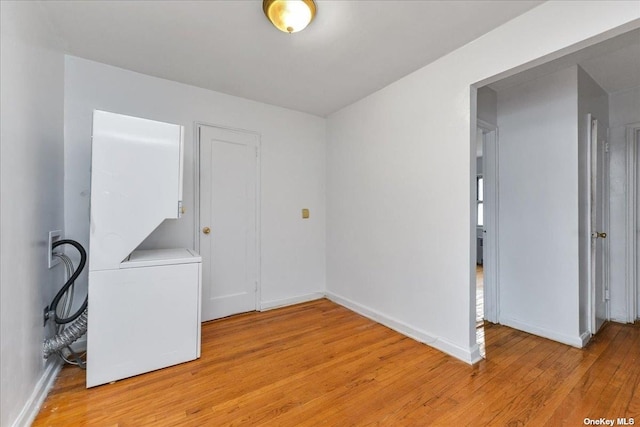 empty room featuring light wood-type flooring, baseboards, and washer / clothes dryer