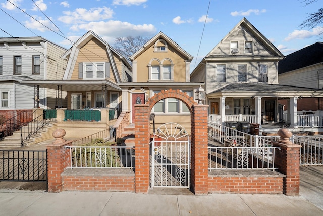 view of front of home featuring stairway, a fenced front yard, and a porch