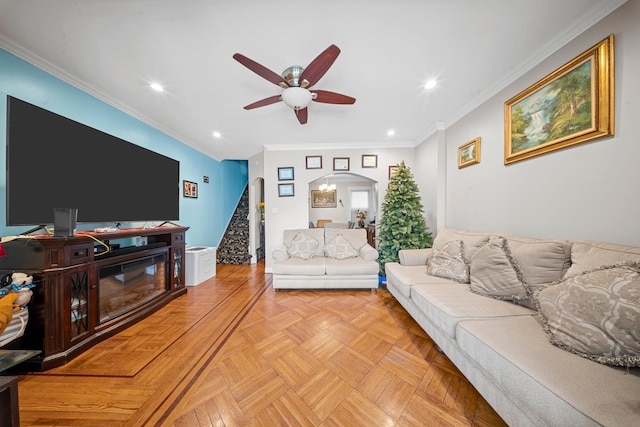 living area featuring arched walkways, crown molding, recessed lighting, and stairs