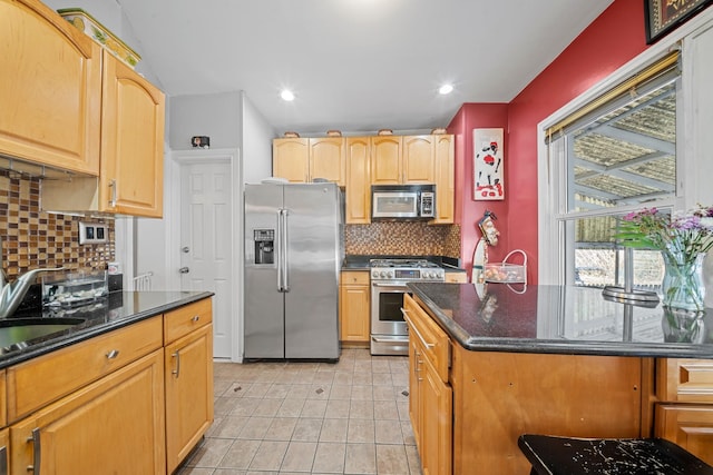 kitchen featuring light tile patterned floors, appliances with stainless steel finishes, backsplash, and a sink