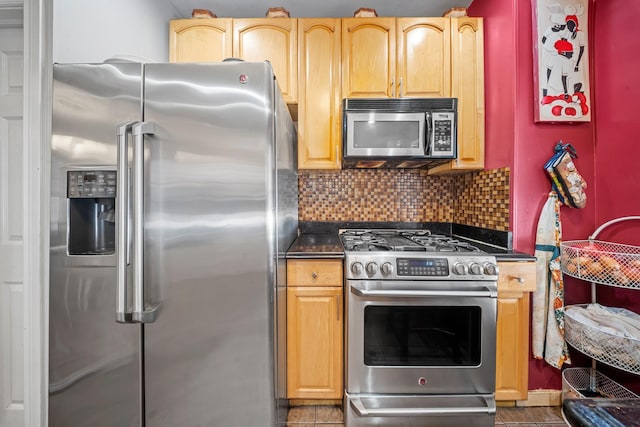 kitchen featuring dark countertops, appliances with stainless steel finishes, and backsplash