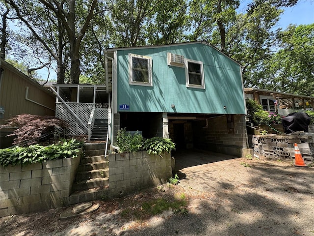 view of outdoor structure featuring driveway, stairs, and a carport