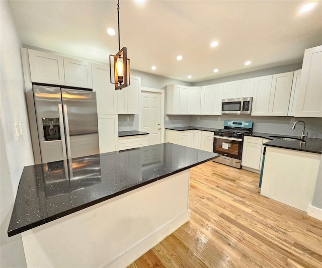 kitchen featuring stainless steel appliances, recessed lighting, light wood-style flooring, white cabinets, and a sink