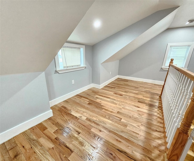 additional living space with lofted ceiling, baseboards, and wood finished floors