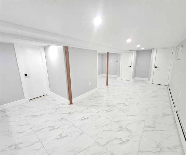 finished basement with marble finish floor, a baseboard radiator, baseboards, and recessed lighting