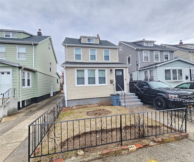 american foursquare style home with entry steps and fence