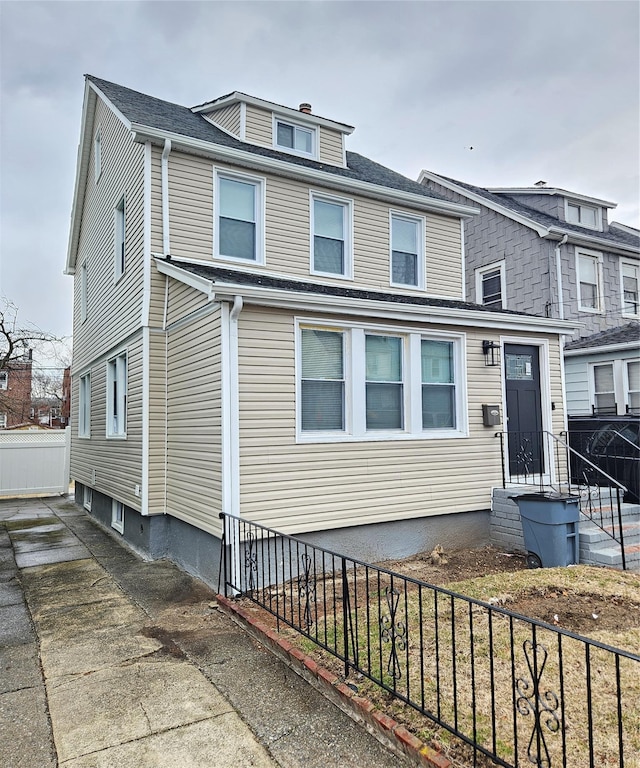 american foursquare style home with fence