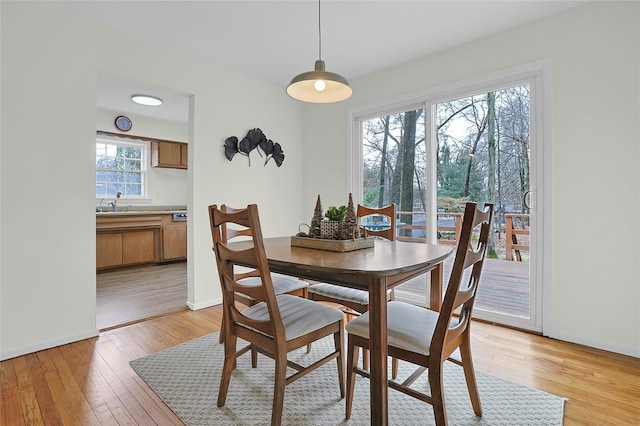 dining area featuring light wood-style flooring and baseboards