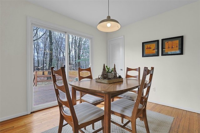 dining space featuring light wood-style floors and baseboards