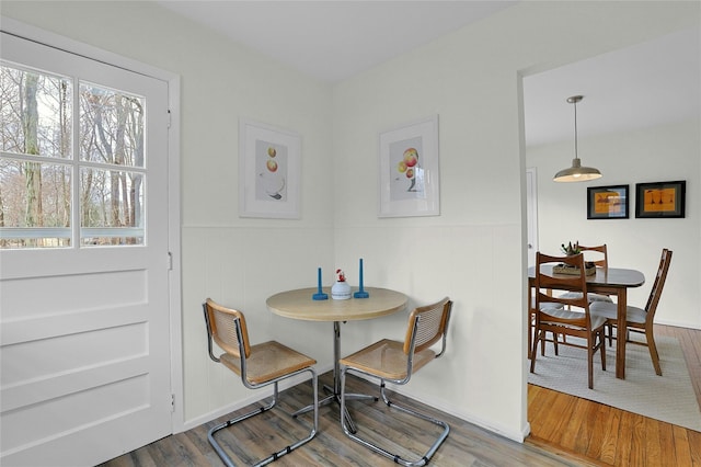 dining space featuring a wainscoted wall and wood finished floors