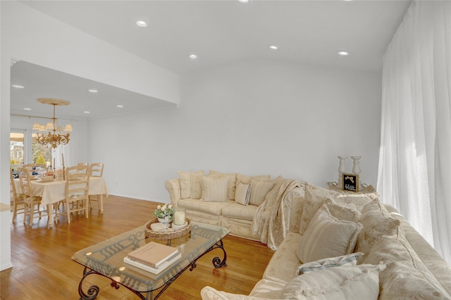 living area featuring baseboards, recessed lighting, an inviting chandelier, and light wood-style floors